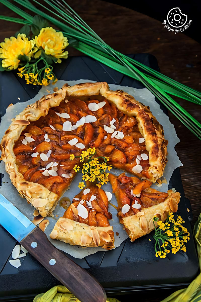 puff pastry apricot galette with almond topping with two cut slices on a cutting board