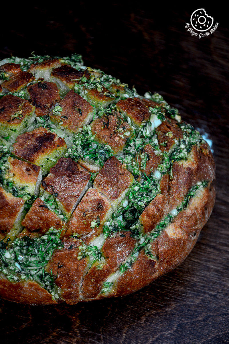 a loaf of pull apart garlic parsley bread on a brown table