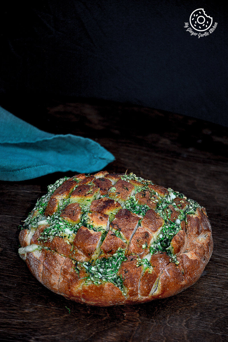 a pull apart garlic parsley bread with a napkin on side