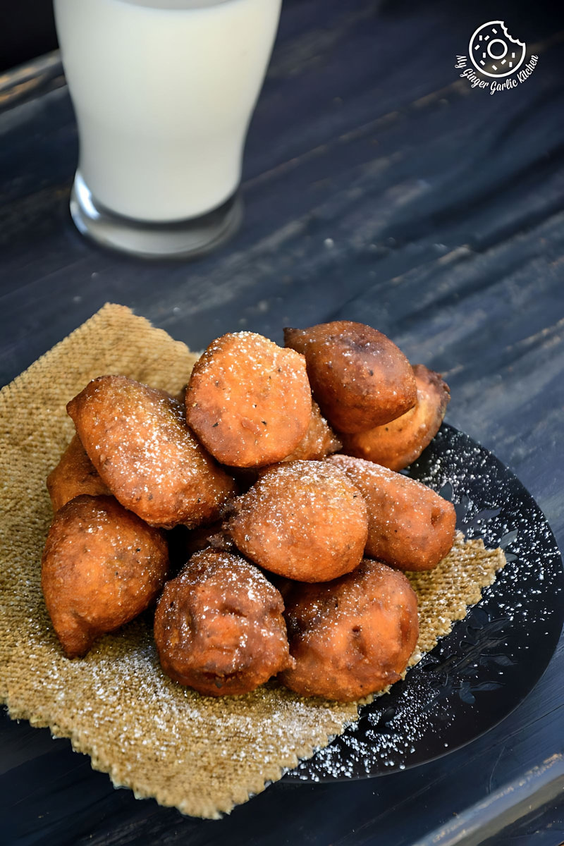 a plate of pumpkin fritters on a table with a glass of milk
