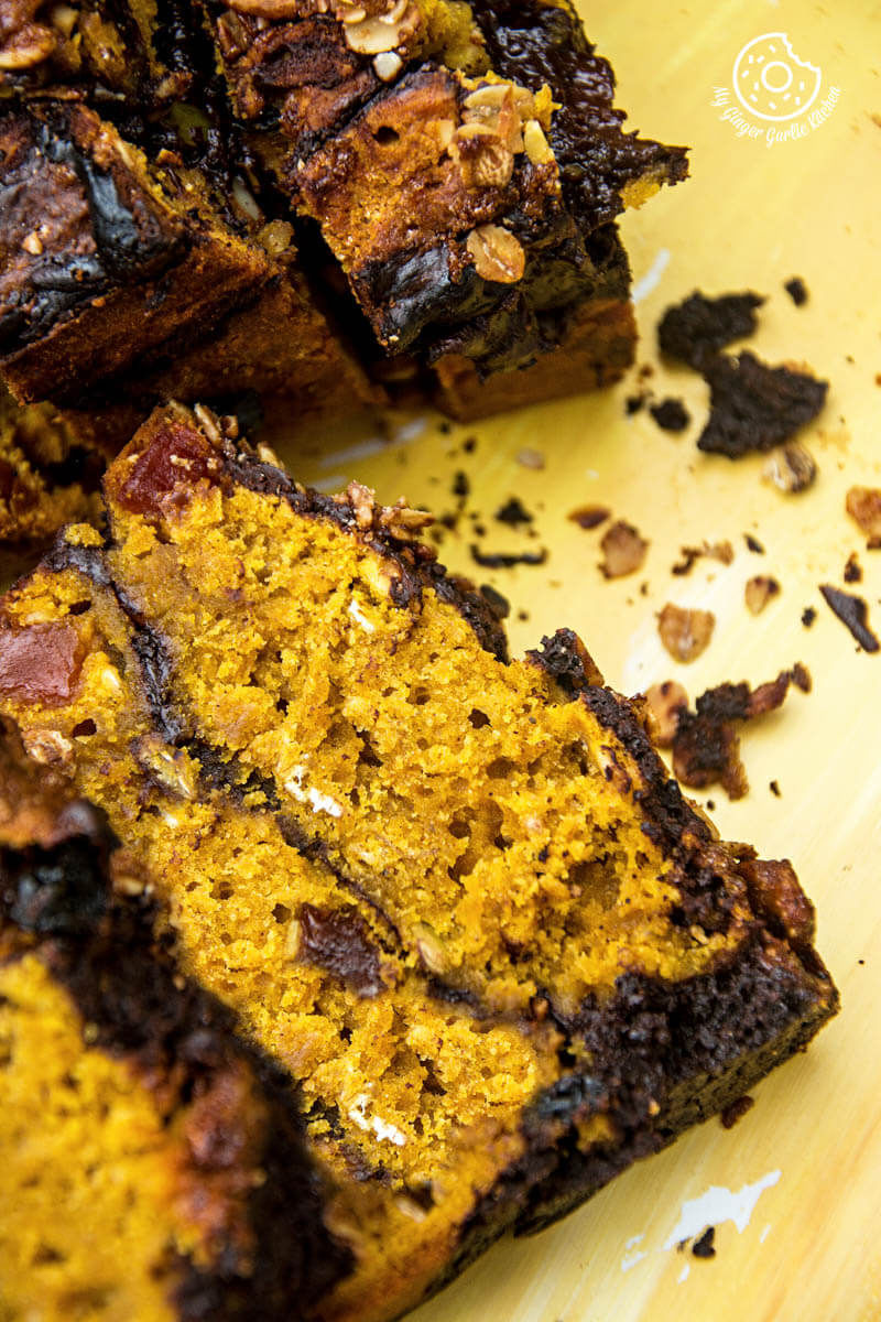 a few slices of pumpkin muesli chocolate bread on a yellow surface