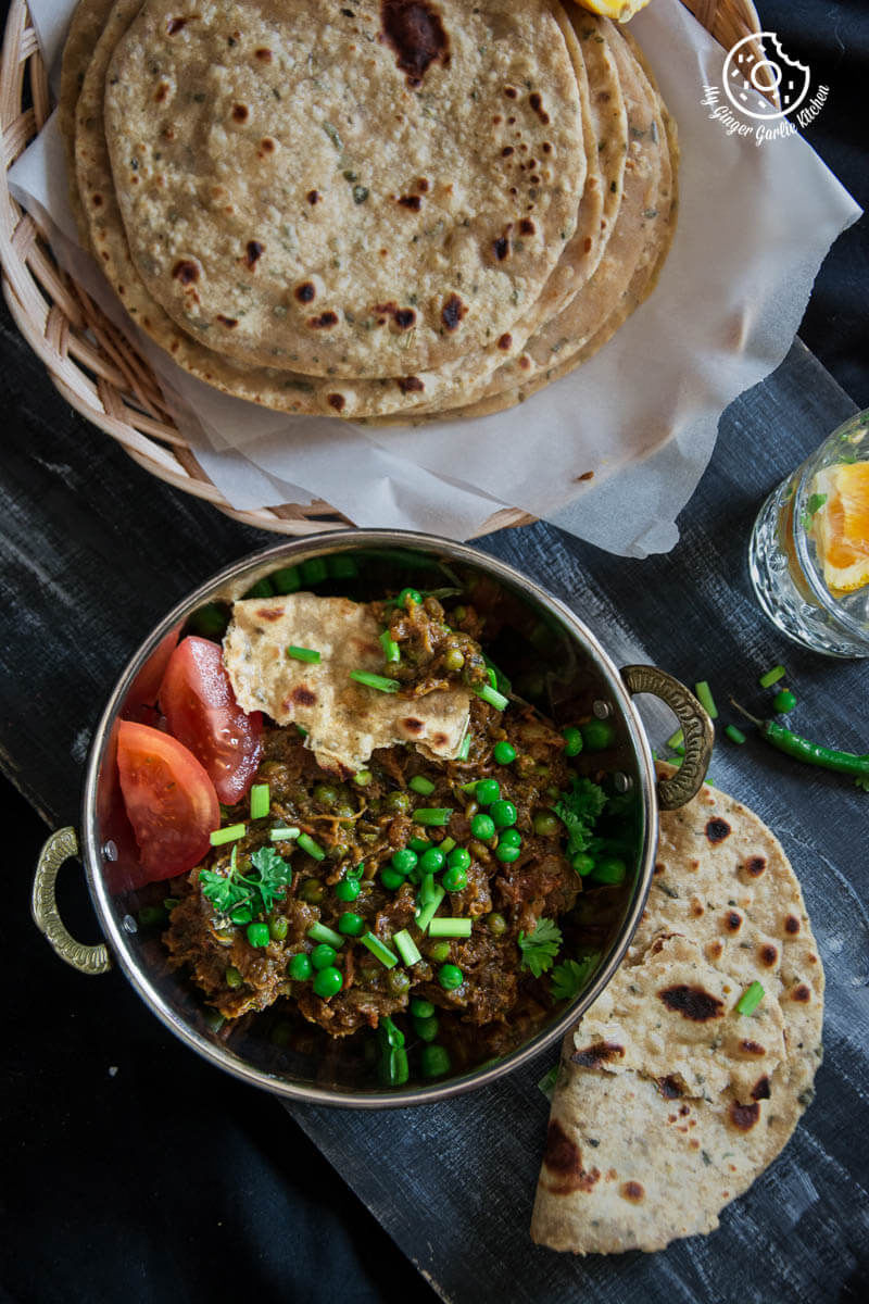 there is a bowl of Punjabi Baingan Bharta with a lot of food on it