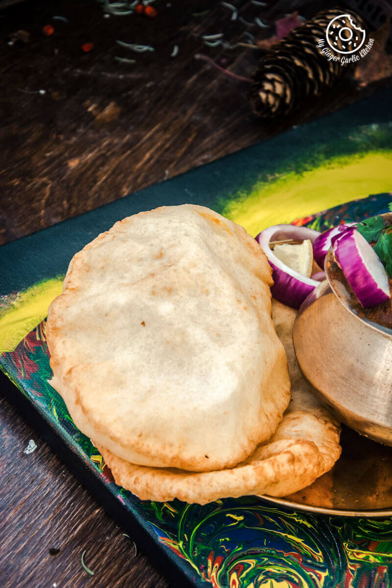 there is a plate with a bhature and red onion slices