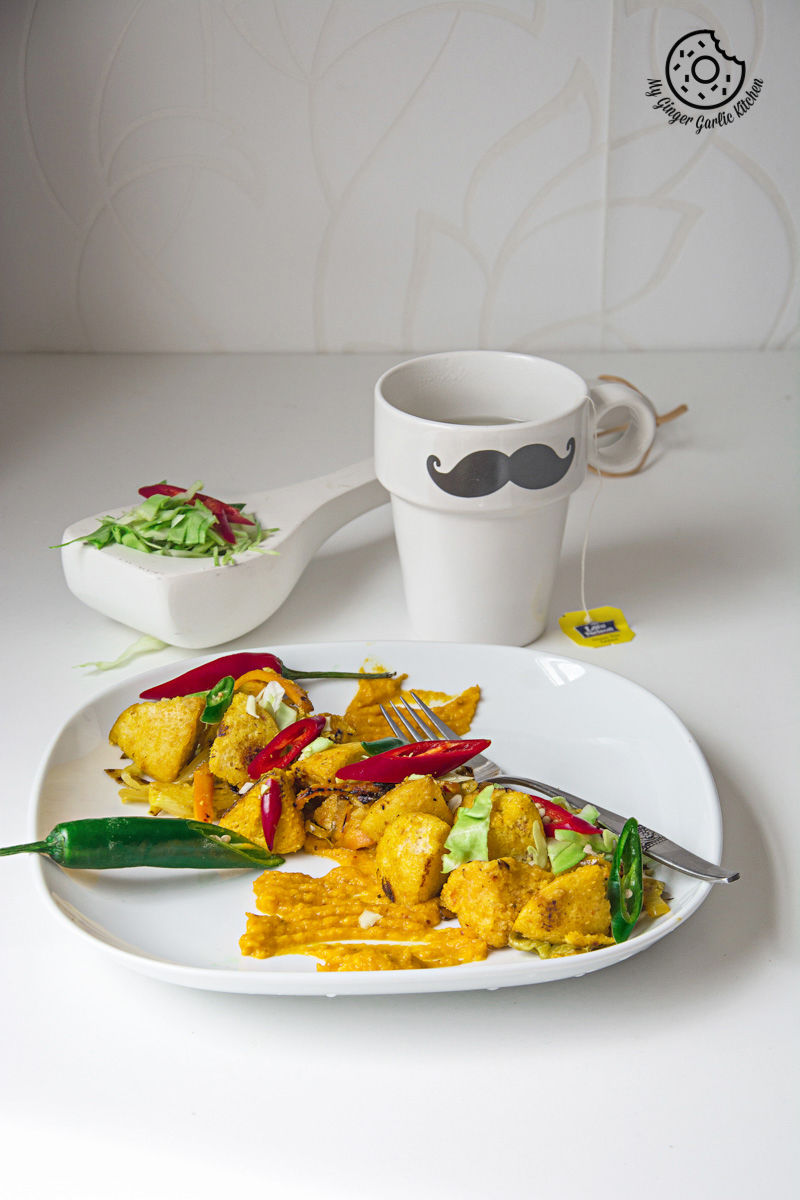 a plate of radish lentil idli fry with carrot ginger chutney with a fork and a cup of tea