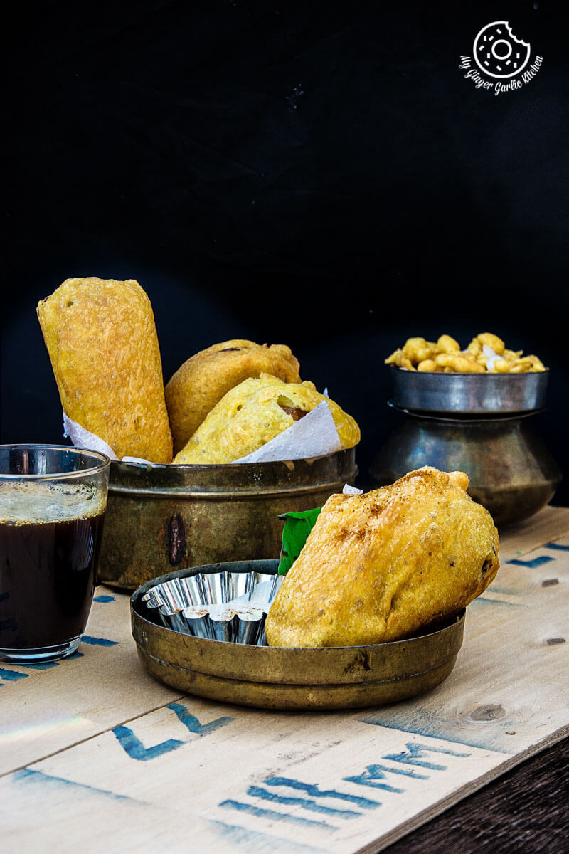 rajasthani mirchi vada on a table with a some more vadas on a table with a glass of coffee