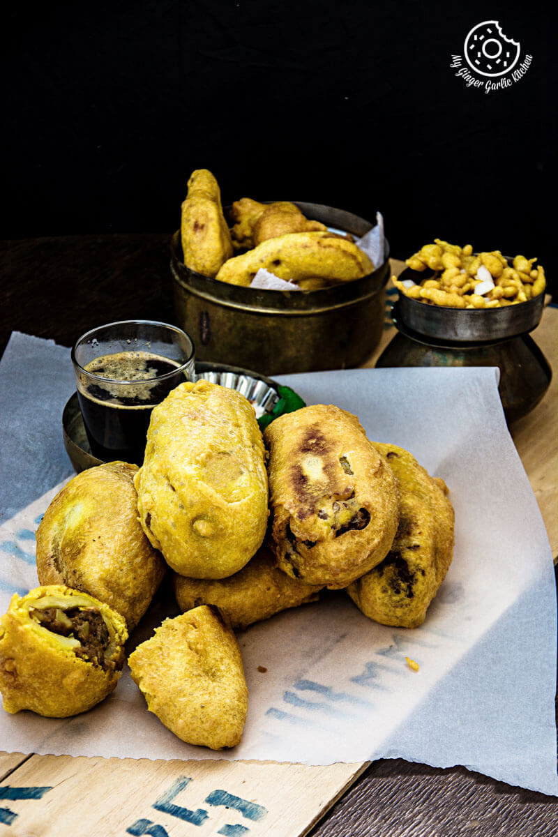 rajasthani mirchi vada on a table with a some more vadas on a table with a glass of coffee