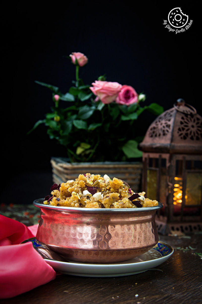 a bowl of rajasthani moong dal halwa on a plate with a candle