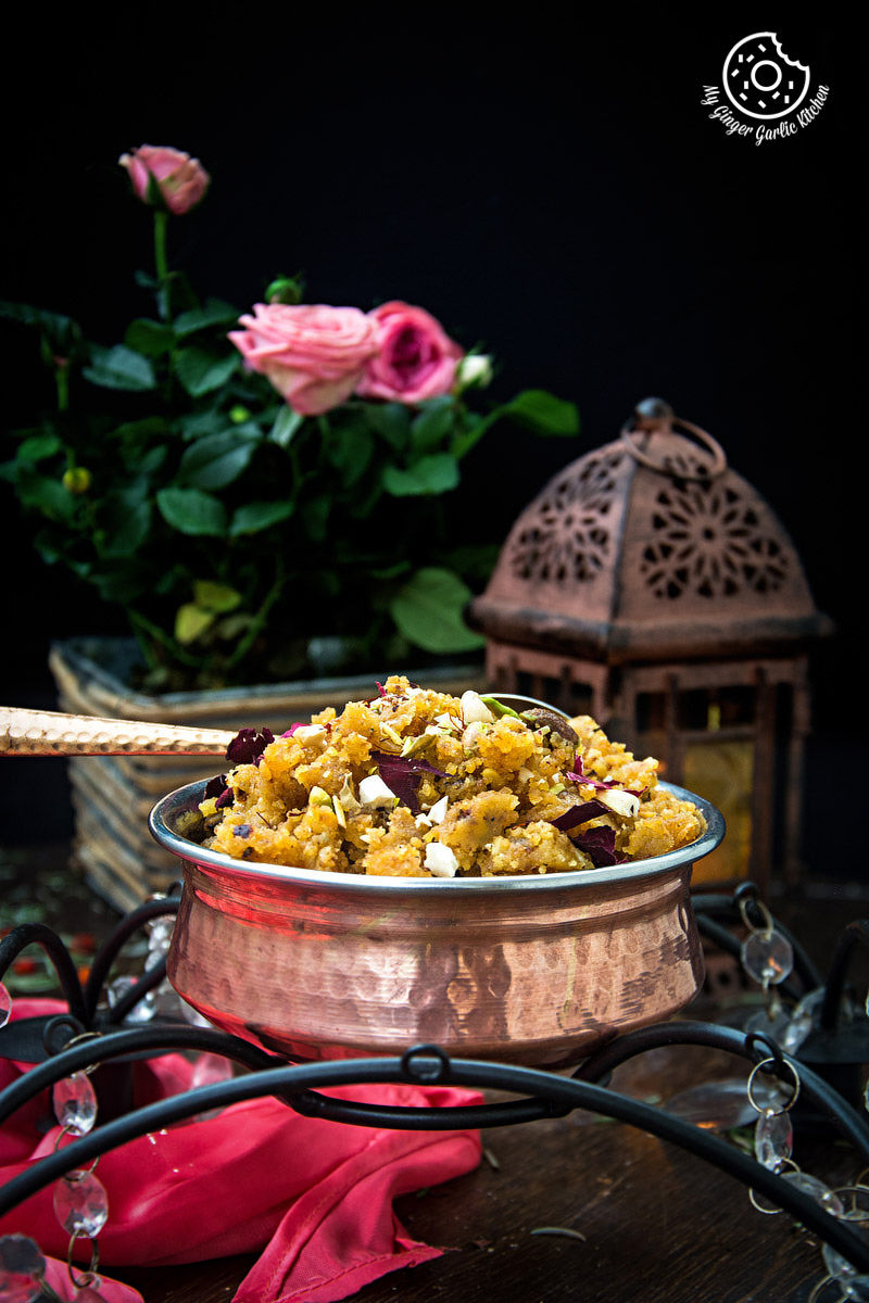a bowl of rajasthani moong dal halwa on a table with a candle