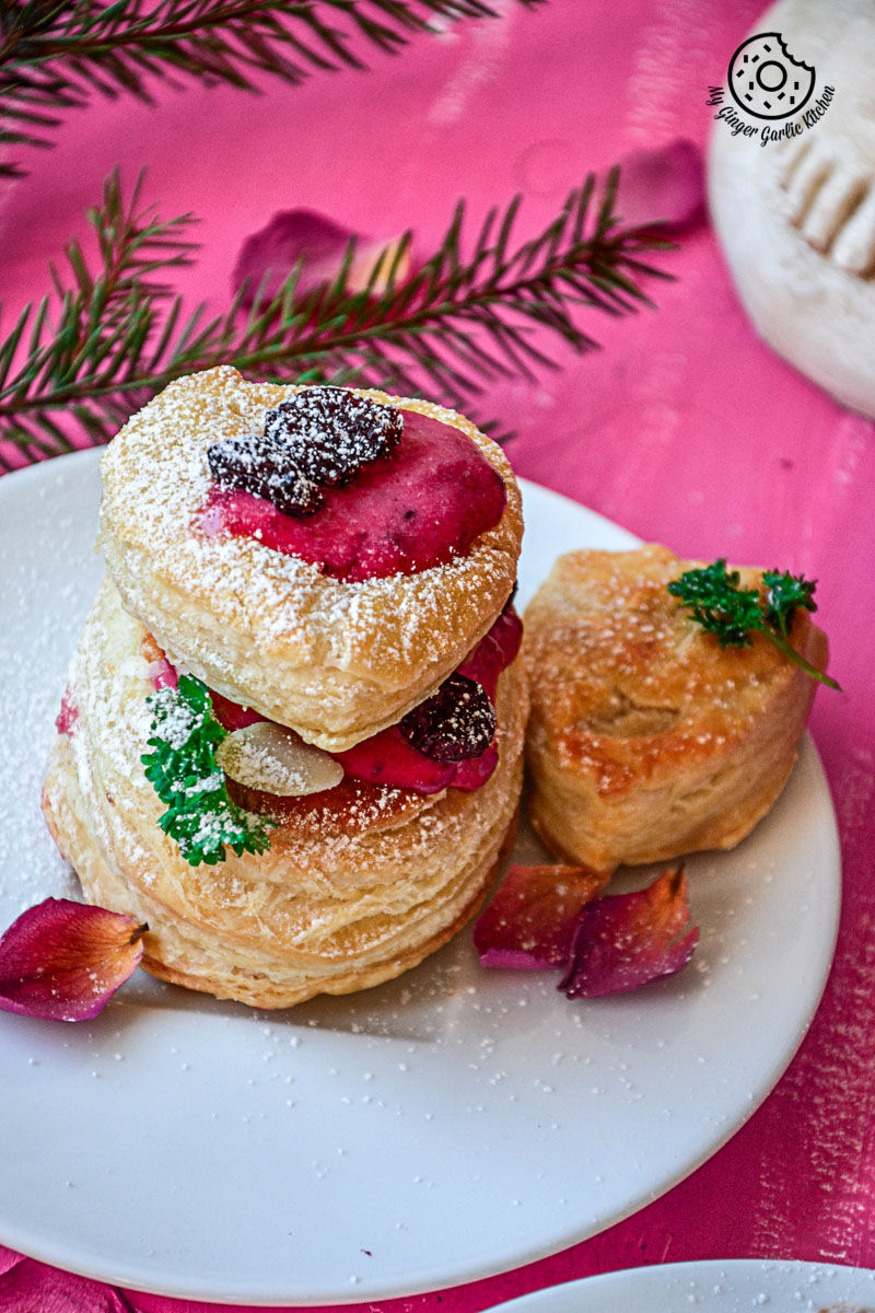 raspberry creme fraiche and cookies puffs on a plate with powdered sugar on them