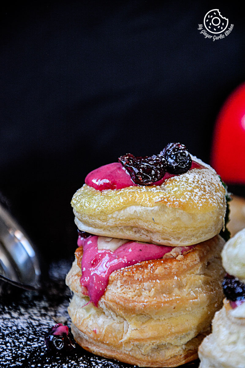 two raspberry creme fraiche and cookies puffs on a black background