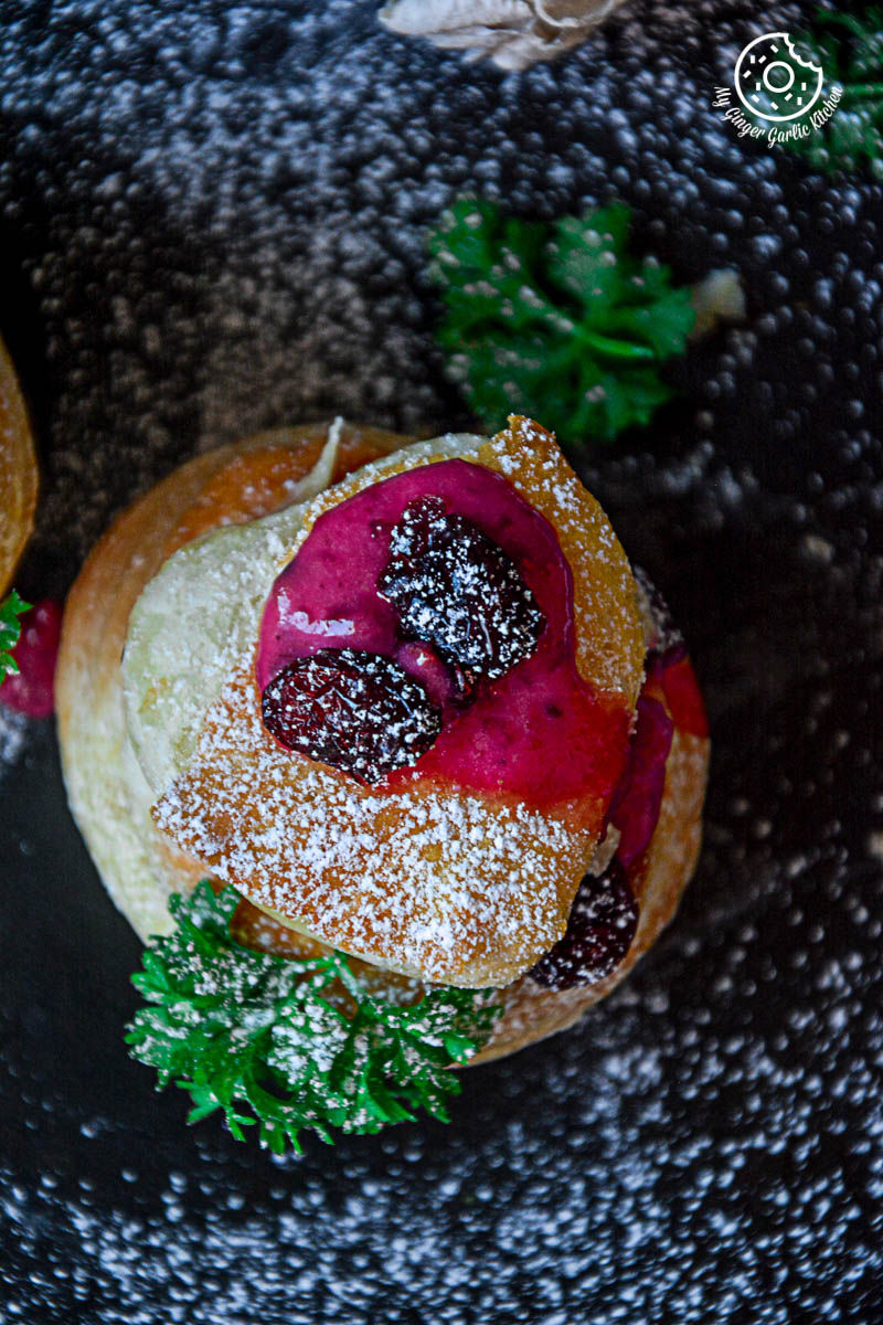 three raspberry creme fraiche and cookies puff on a plate on a table