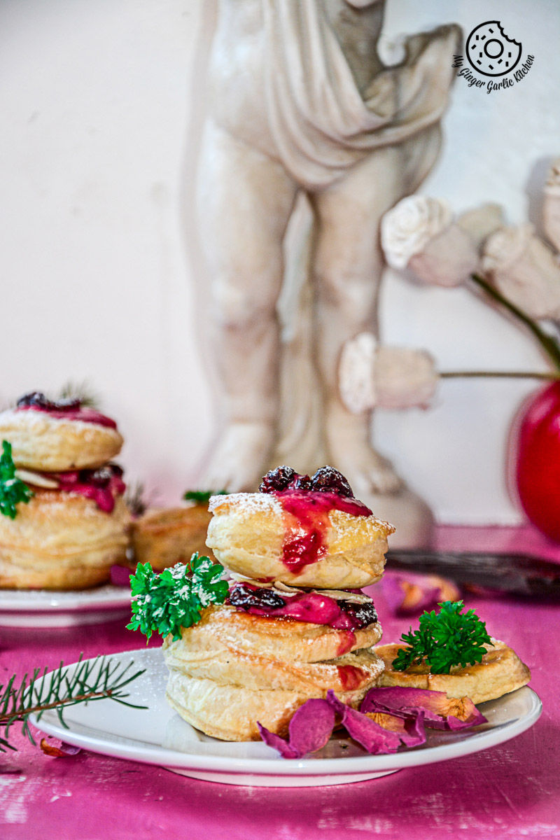 a raspberry creme fraiche and cookies puff on a plate with a statue in the background