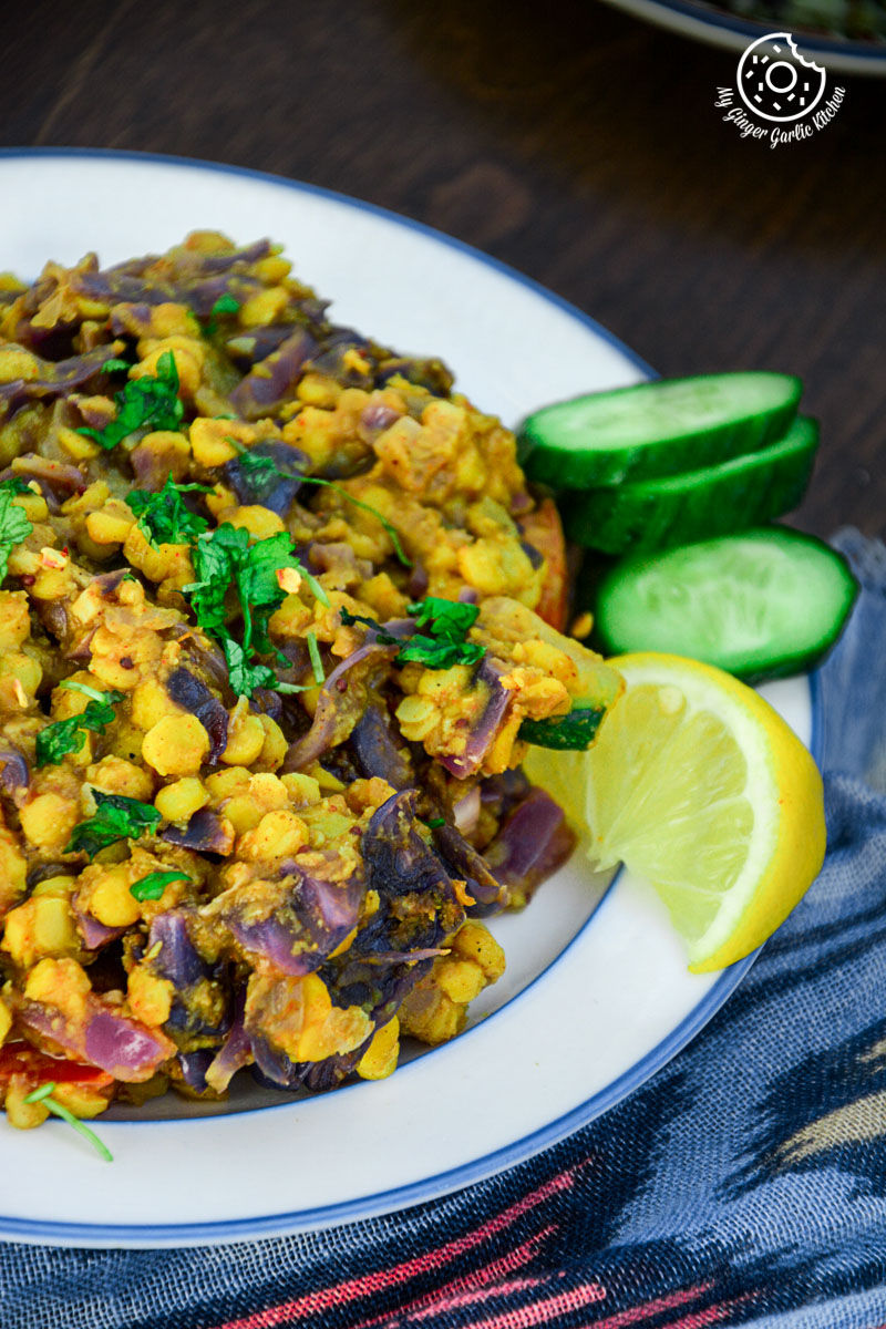 a plate of red cabbage zucchini chana dal with a lemon slice on it