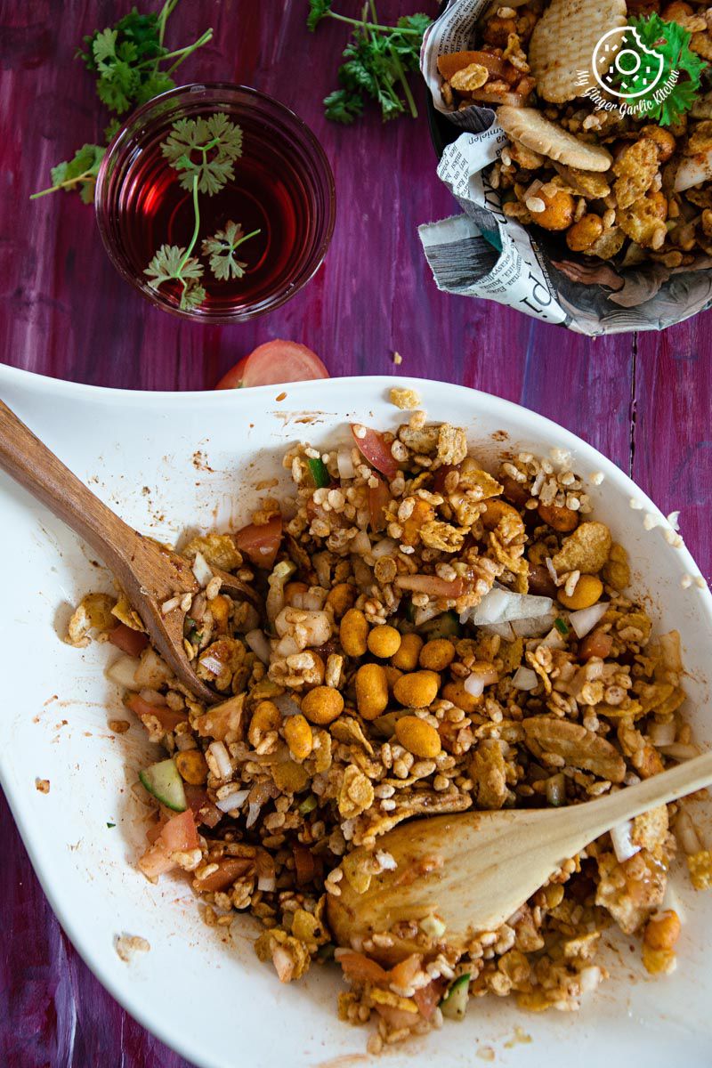 a bowl of rice krispie cornflakes bhel with a wooden spoon in it