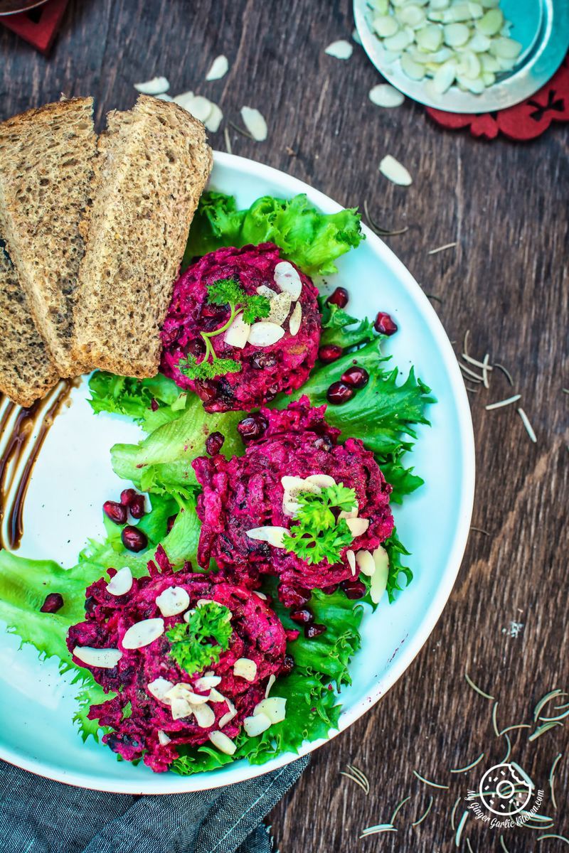 a plate of roasted beet potato holiday salad with bread slices on it