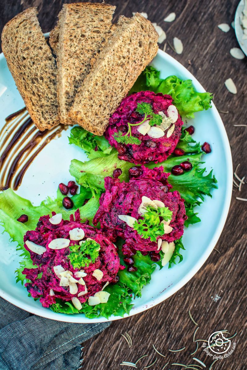 a plate of roasted beet potato holiday salad with bread slices on it