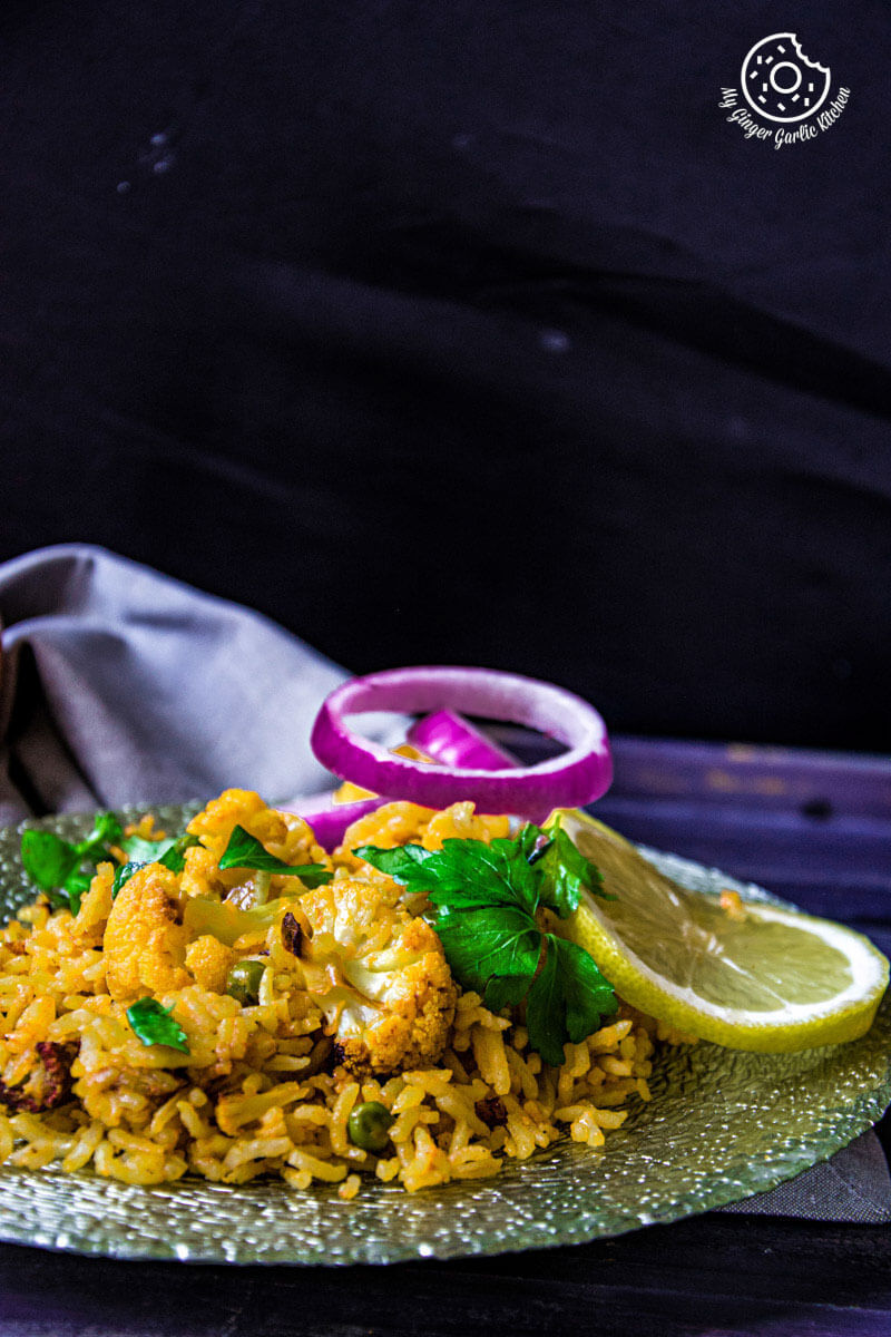 a plate of roasted cauliflower pulao with onions on it