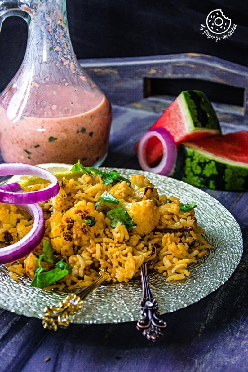 a plate of roasted cauliflower pulav with watermelon sauce on a table
