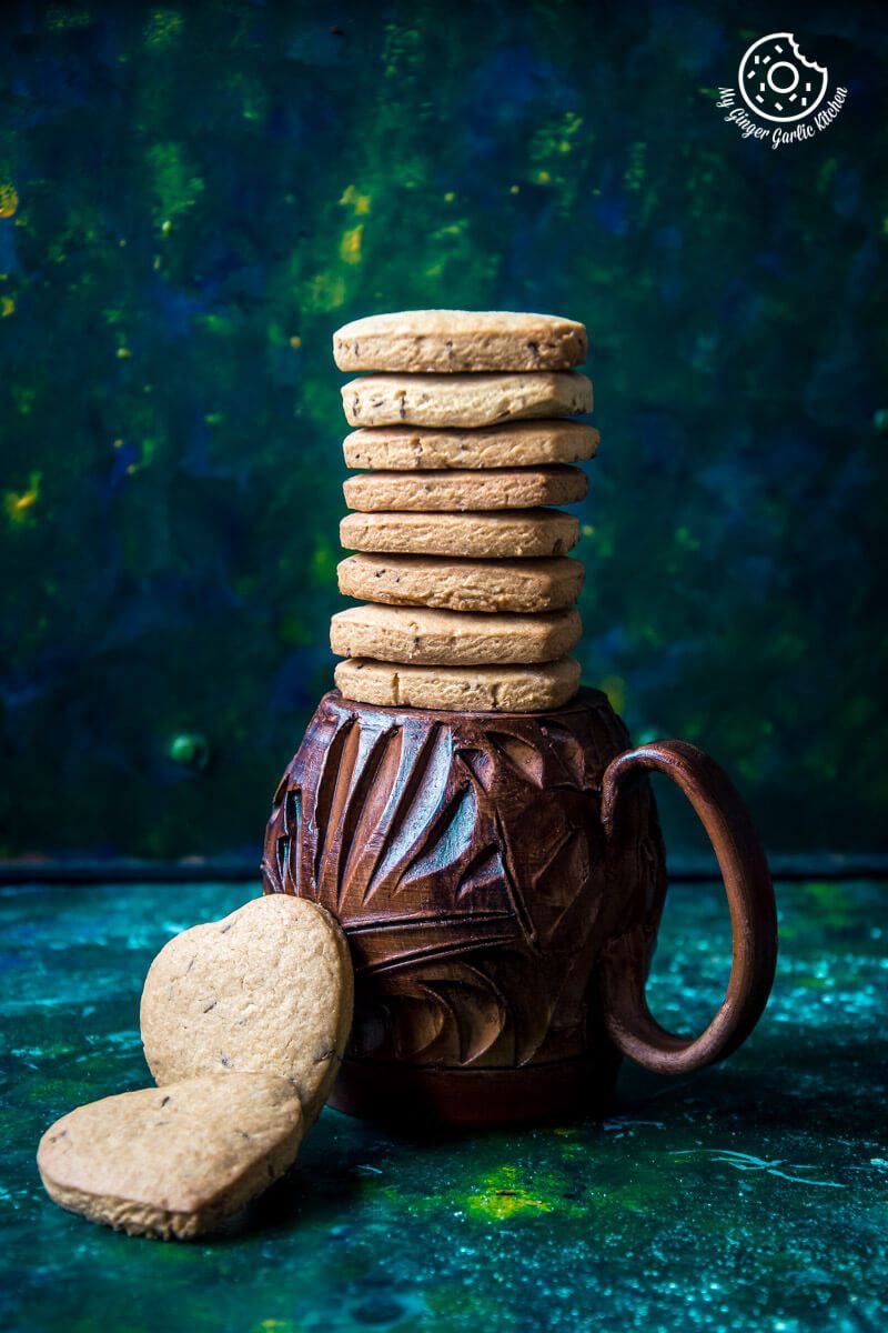 there are a stack of jeera biscuits and a cookie in a mug