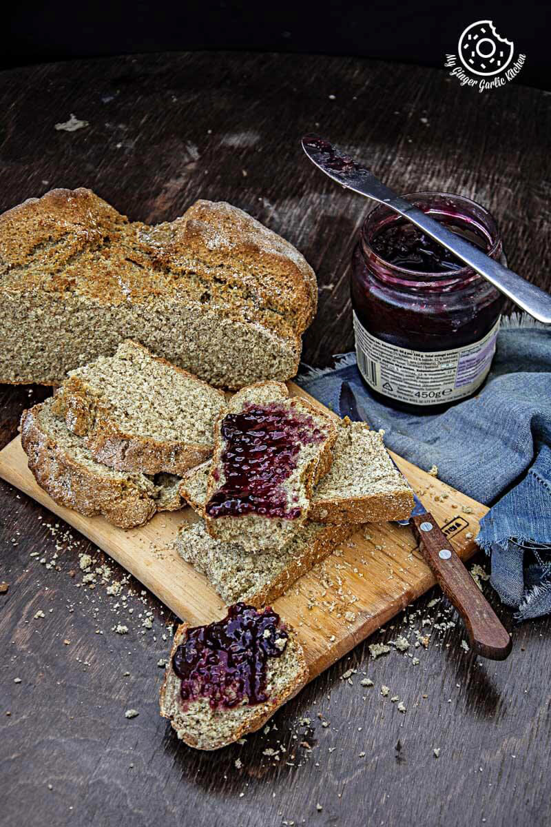 a loaf of rye irish soda bread with jam on a cutting board