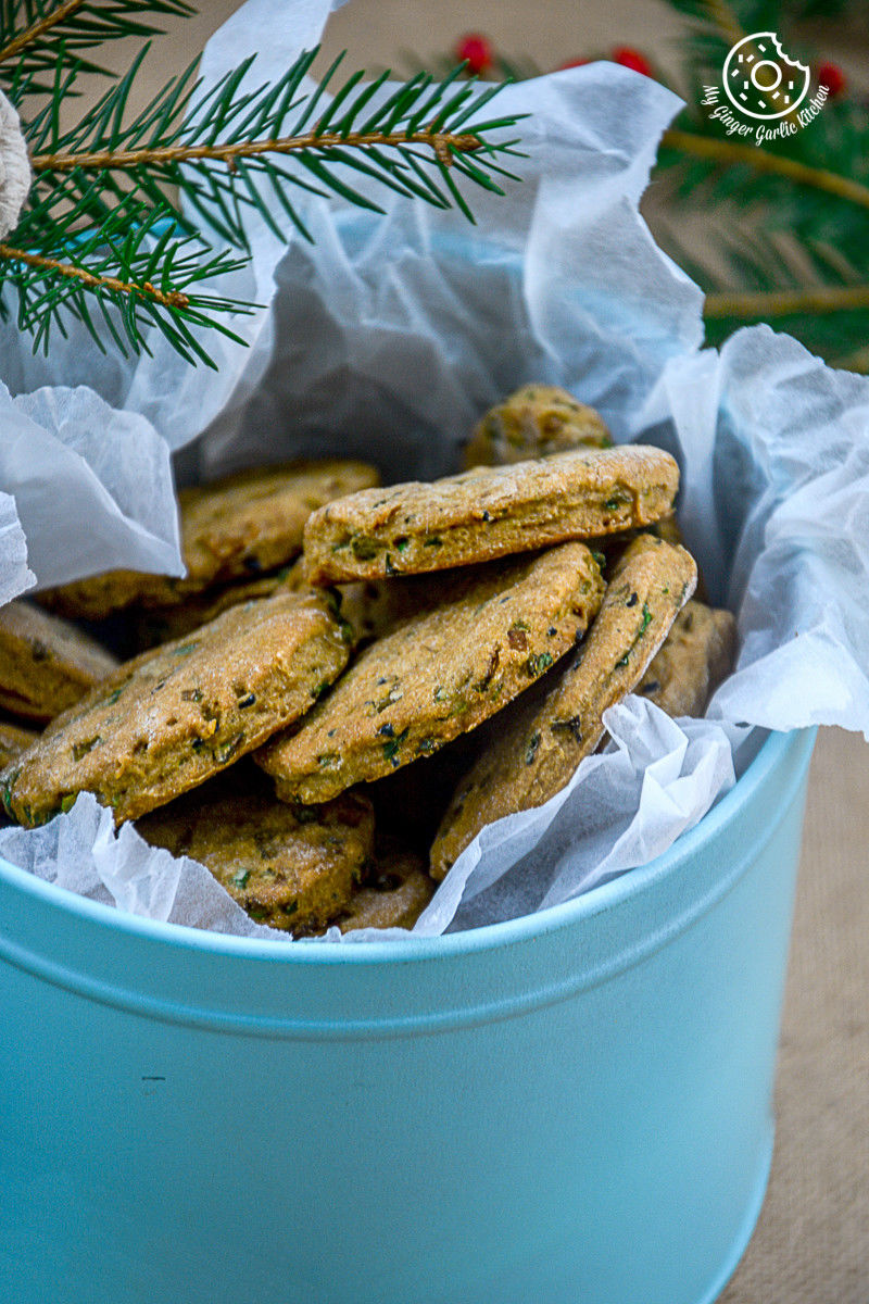 a blue cookie tin filled with salty sweet whole wheat onion crackers and a pine branch