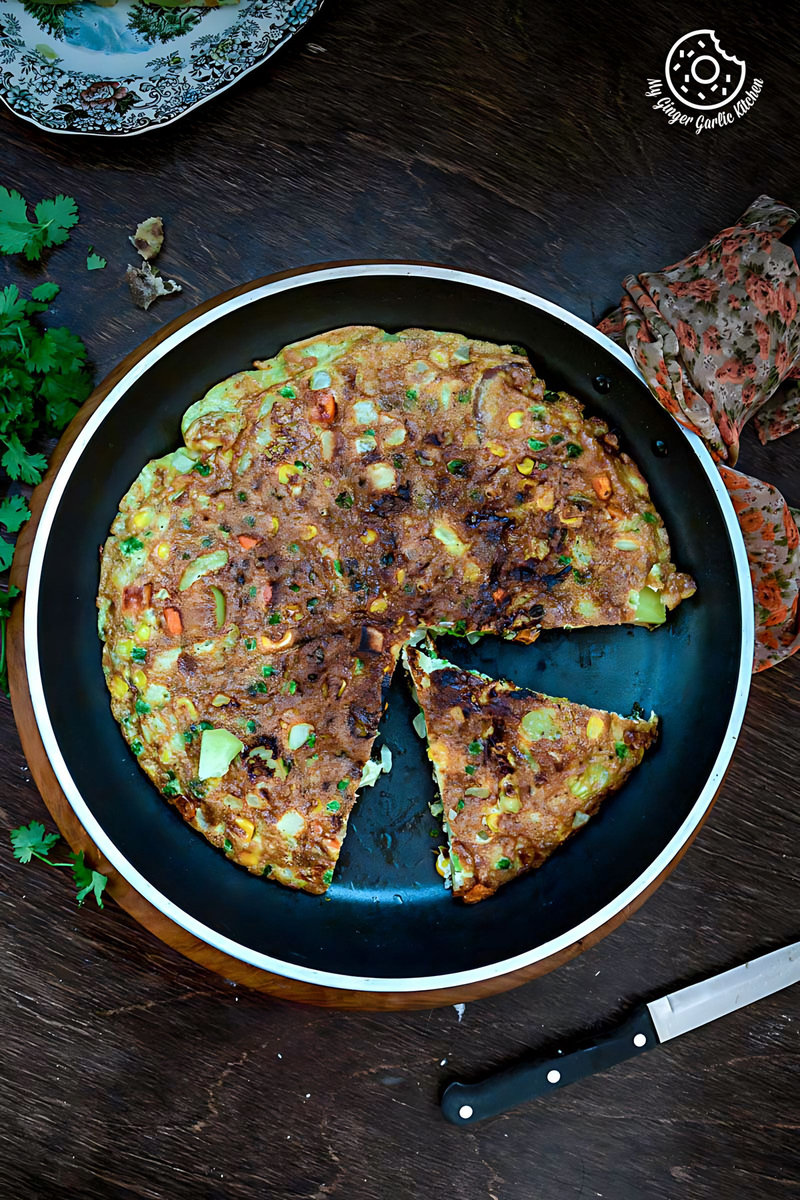 a pan with a spanish style vegetarian omelette on it and a knife