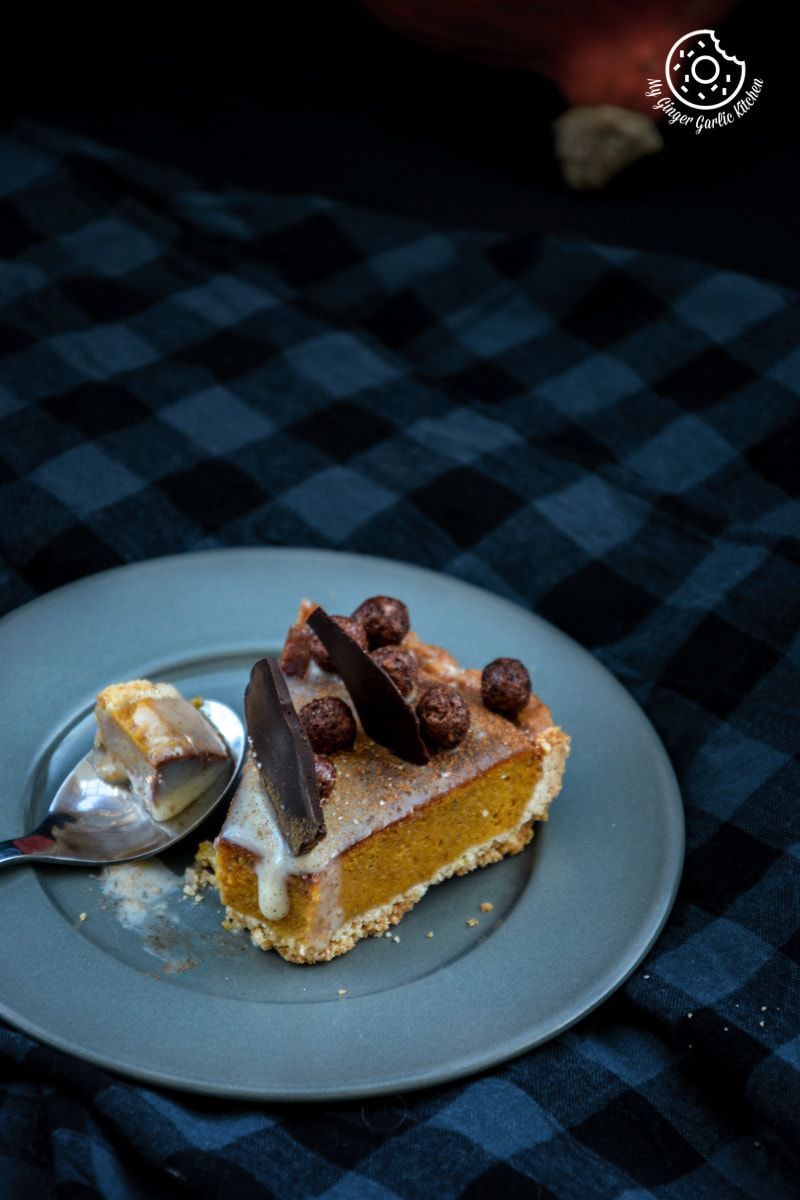 a piece of spiced pumpkin pie on a plate with a spoon