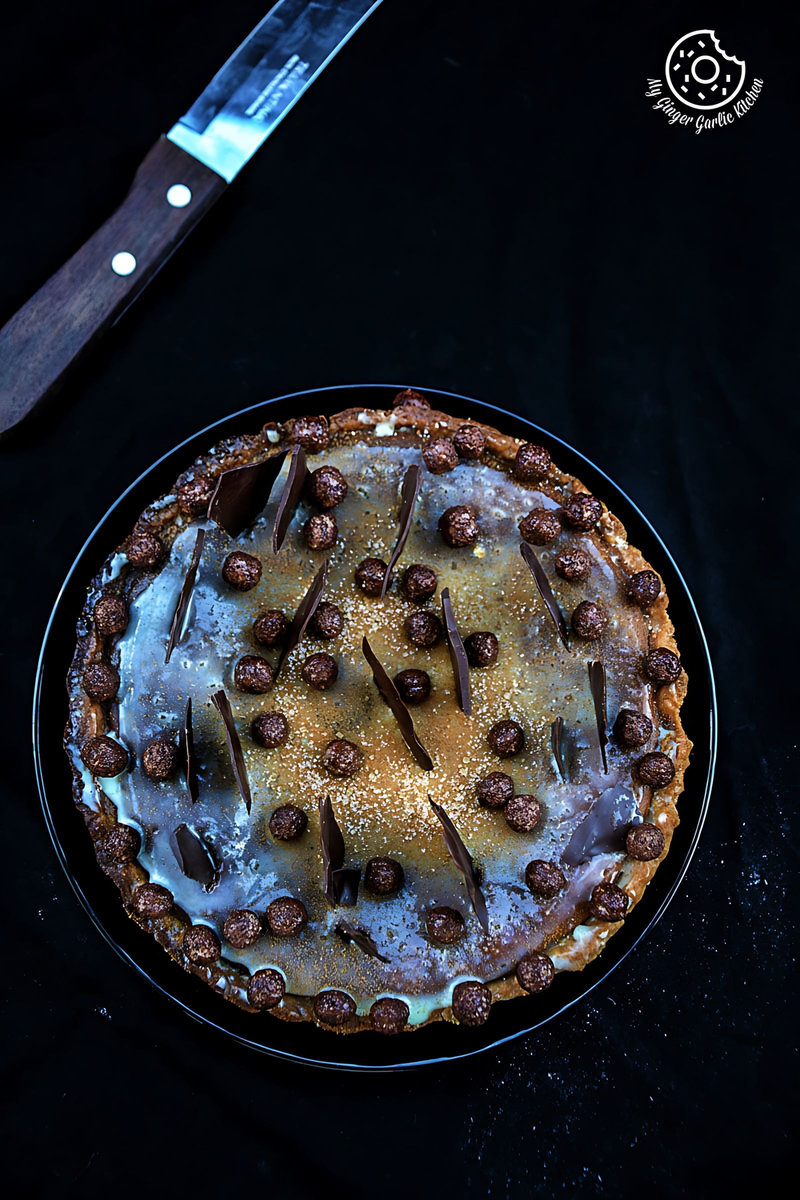 a spiced pumpkin pie with chocolate and candies on it on a plate