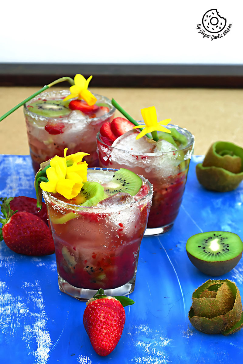 three glasses of strawberry kiwi sparkling cooler with strawberries and kiwi