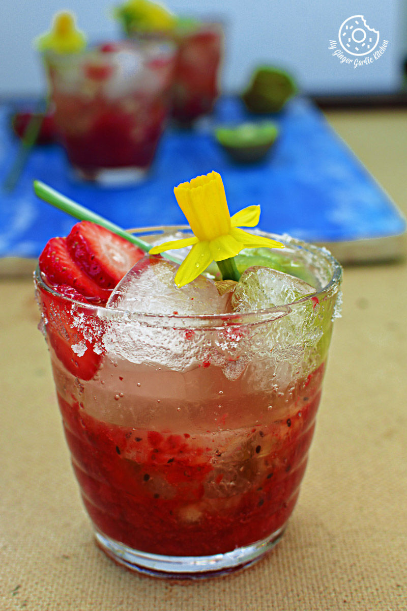 a glass of strawberry kiwi sparkling cooler with a flower on top