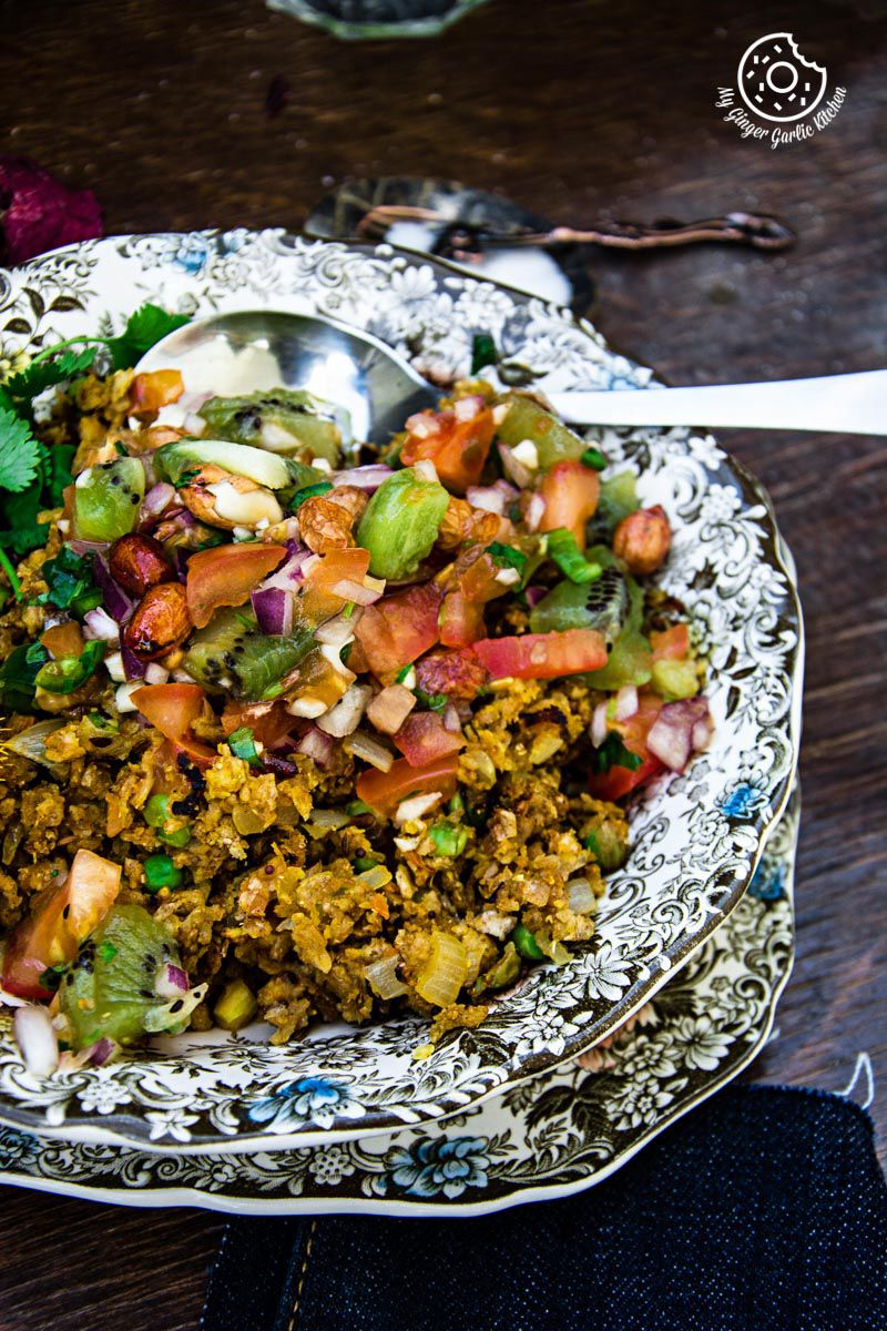 a plate of tortilla poha topped with kiwi peanut salsa on a table
