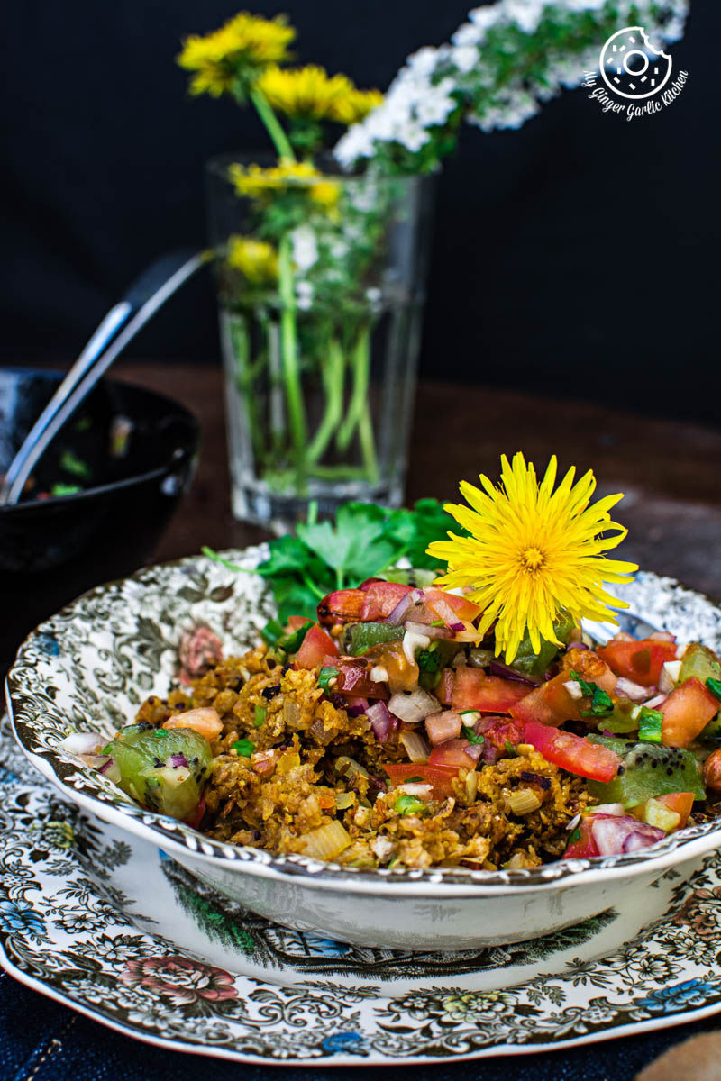 a plate of tortilla poha topped with kiwi peanut salsa with a flower on top of it
