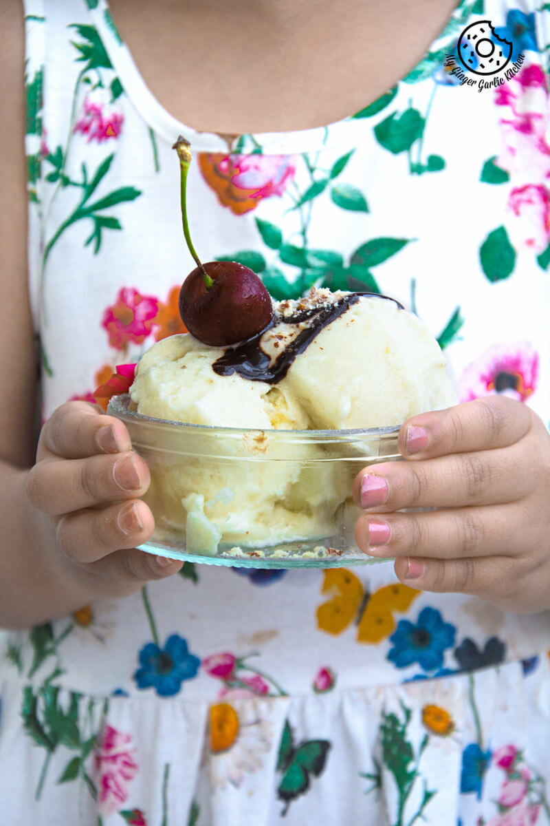 a kid holding a bowl of vegan honeydew melon banana ice cream and a cherry