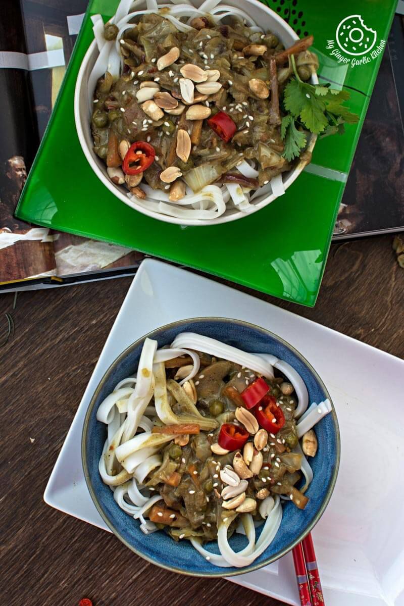 two bowl vegan thai green curry vegetable noodles on a table with a book