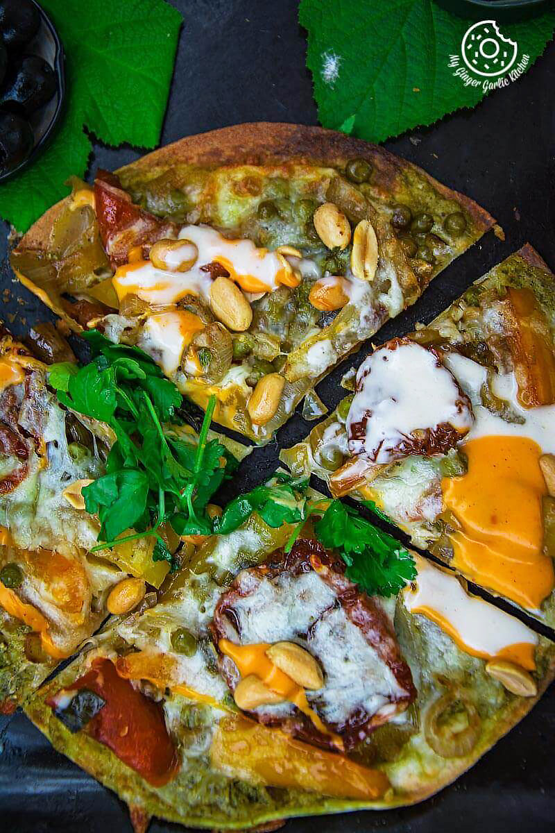 a veggie tortizza or tortilla pizza with cheese, spinach, and other toppings on it