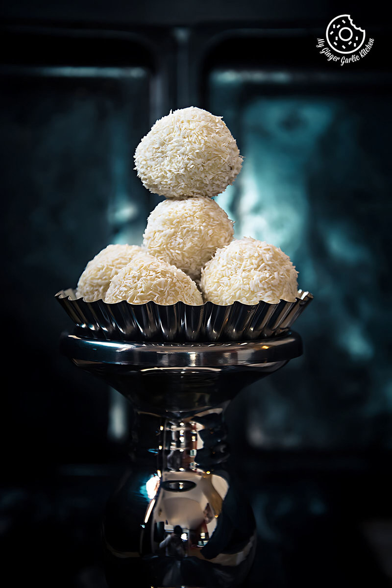 three white chocolate coconut truffles on a silver plate
