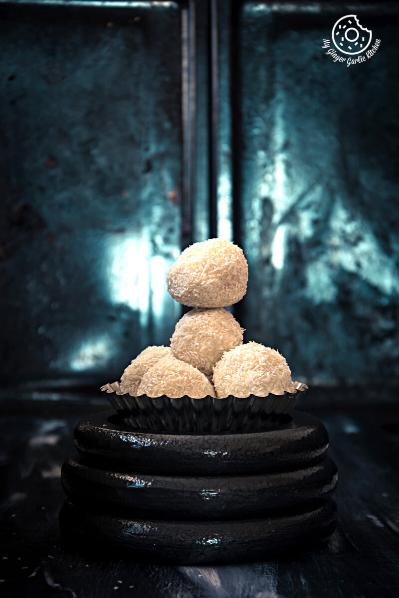 five white chocolate coconut truffles stacked on top of each other on a plate