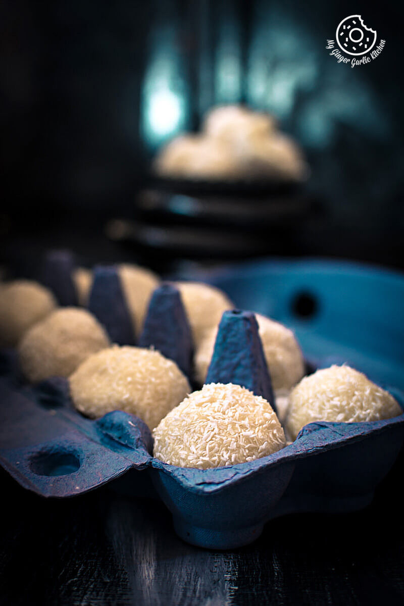 white chocolate coconut truffles in a blue egg carton on a table