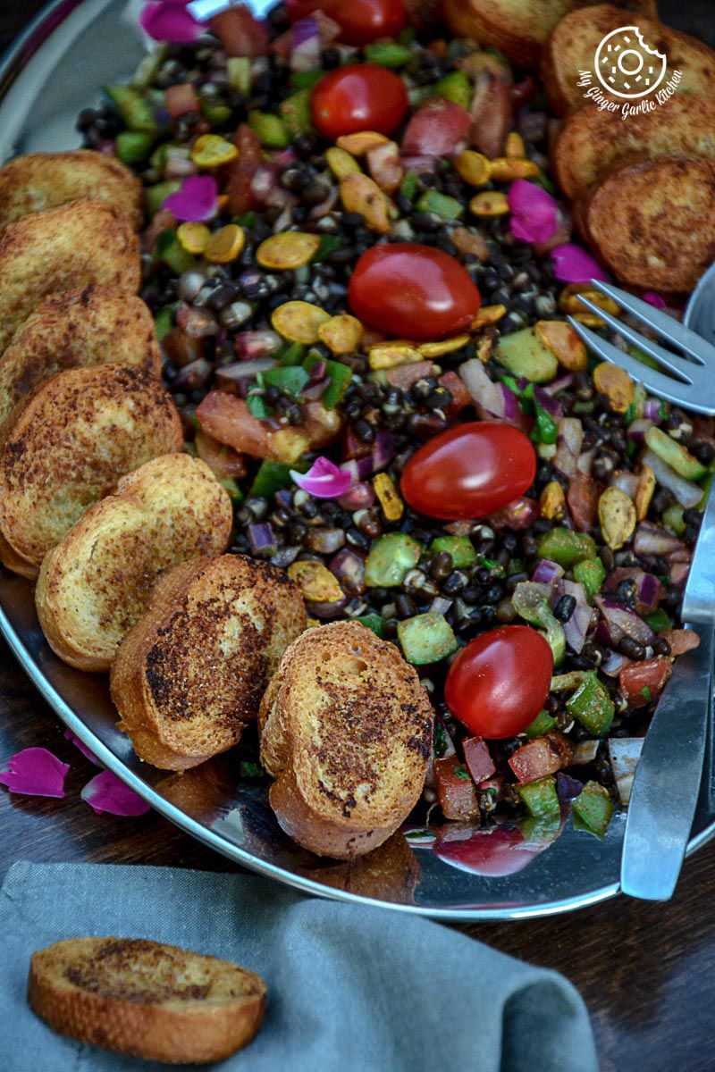 a plate of whole black gram sprouts with garlic oven toasted baguette on it