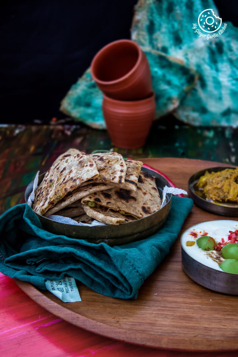 some cabbage peas stuffed parathas or patta gobi paratha on a wooden tray on a table