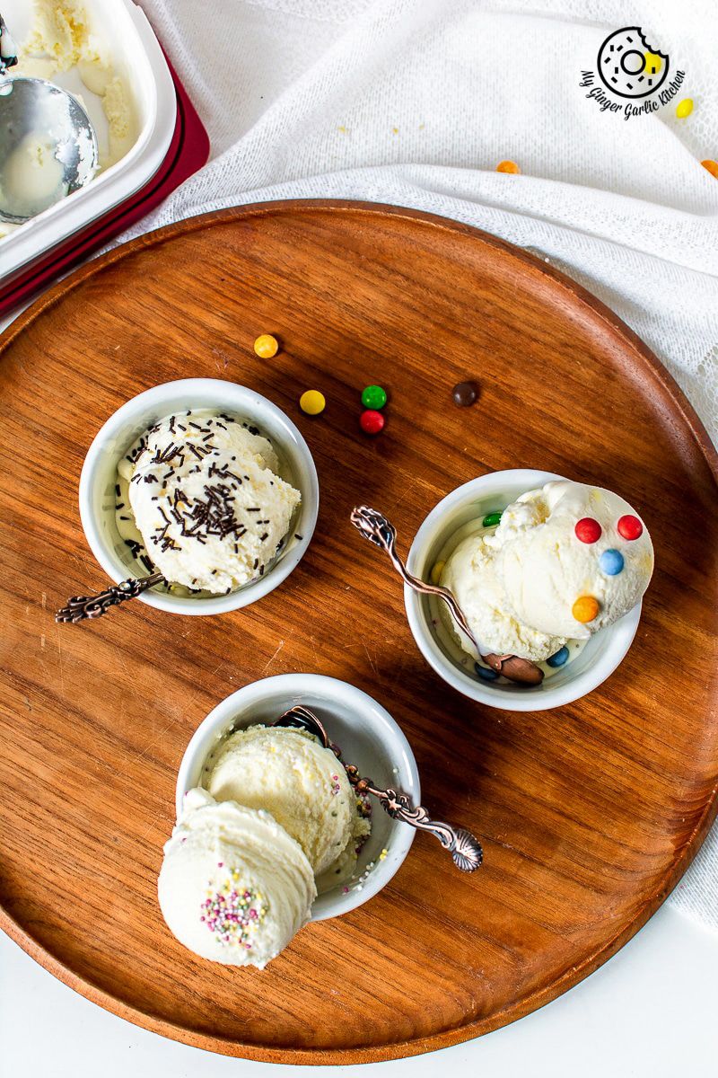 three bowls of no churn homemade vanilla ice cream on a wooden tray