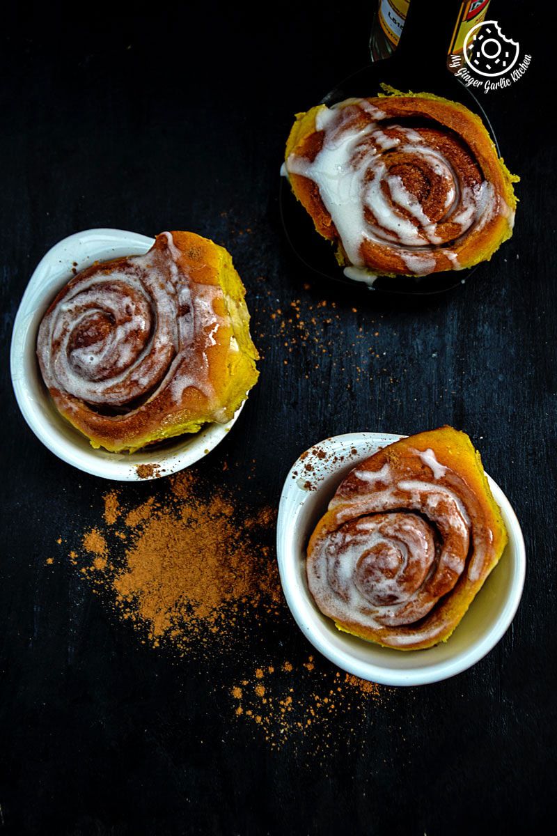 three small white bowls filled with cinnamon cinnamon rolls on a table