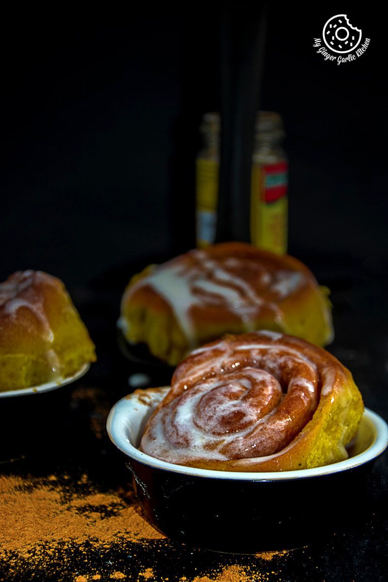 three rolls of pumpkin cinnamon buns on a plate