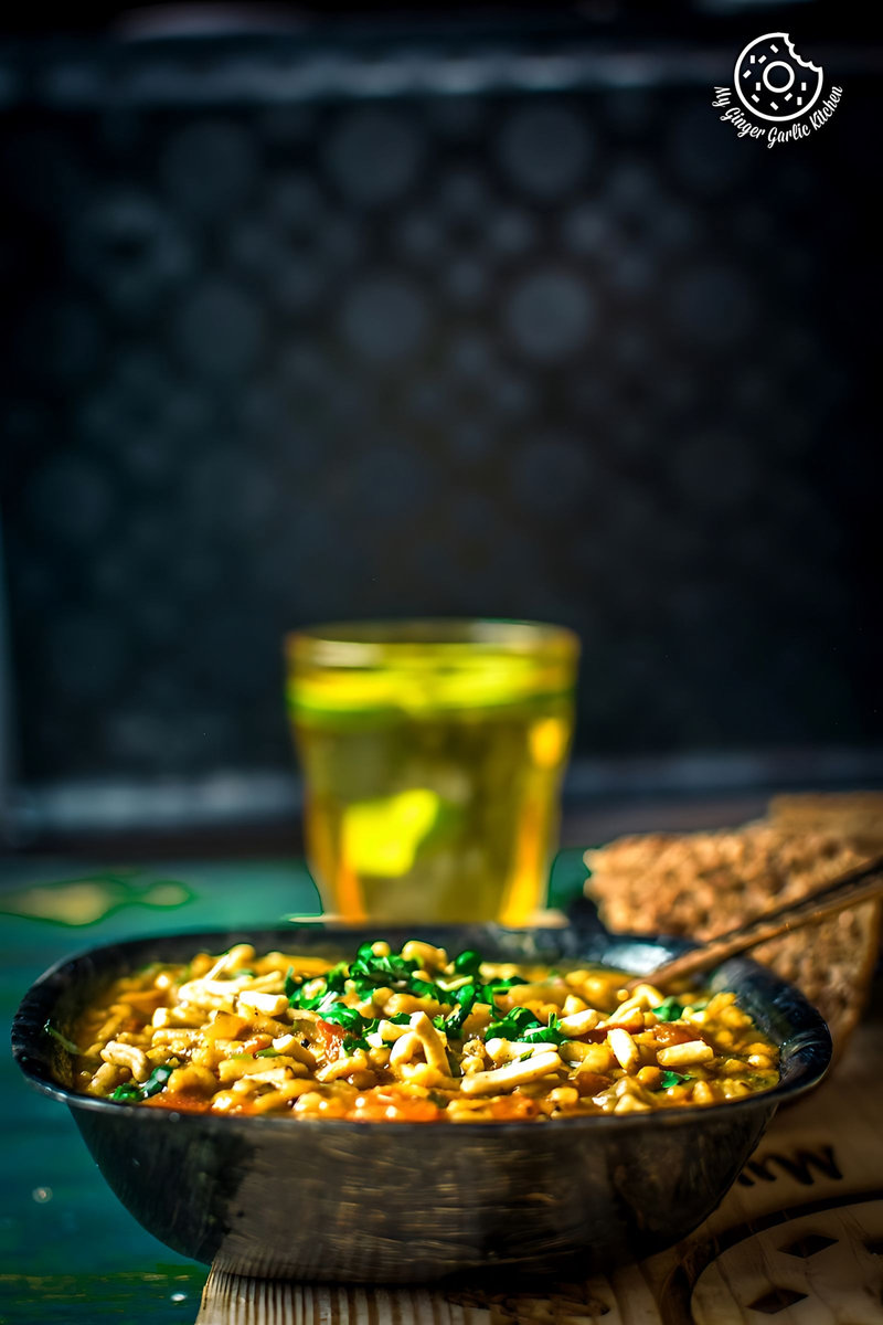 there is a bowl of rajasthani sev tamatar ki sabji that is sitting on a table