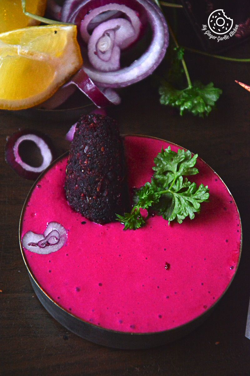 there is a plate of beet dip with a roasted beet kebab in it