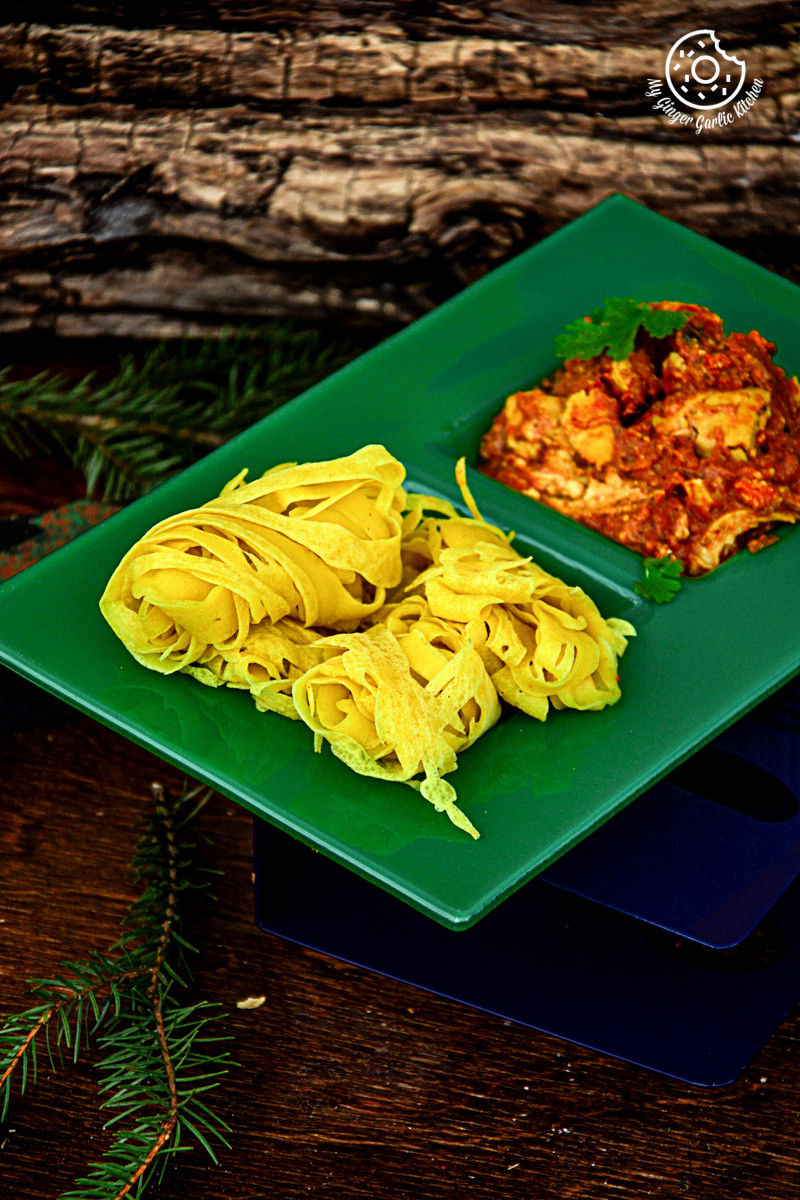 a green plate with roti jala and egg curry on it