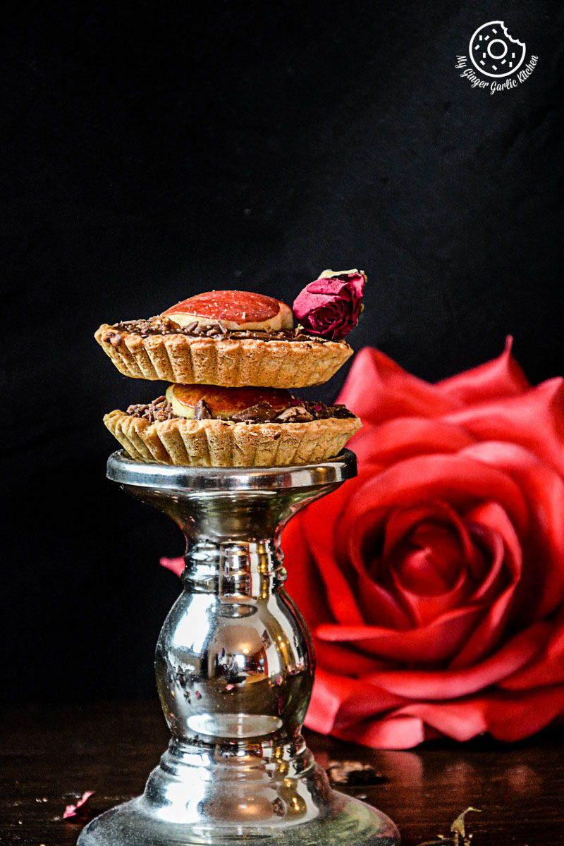 a silver plate with snickers chocolate mini tarts and a rose on it