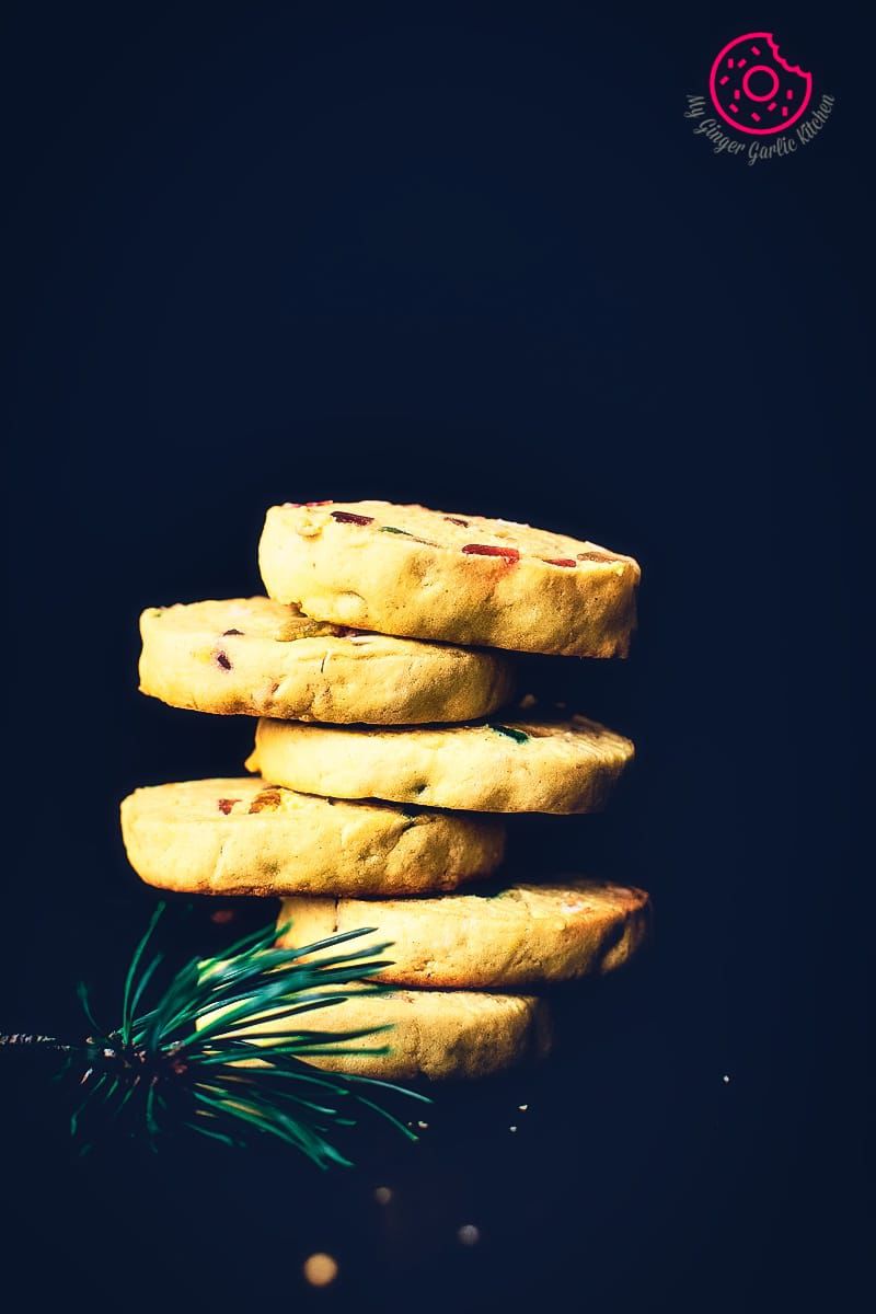 a stack of tutti frutti biscuit with a sprig of rosemary on top