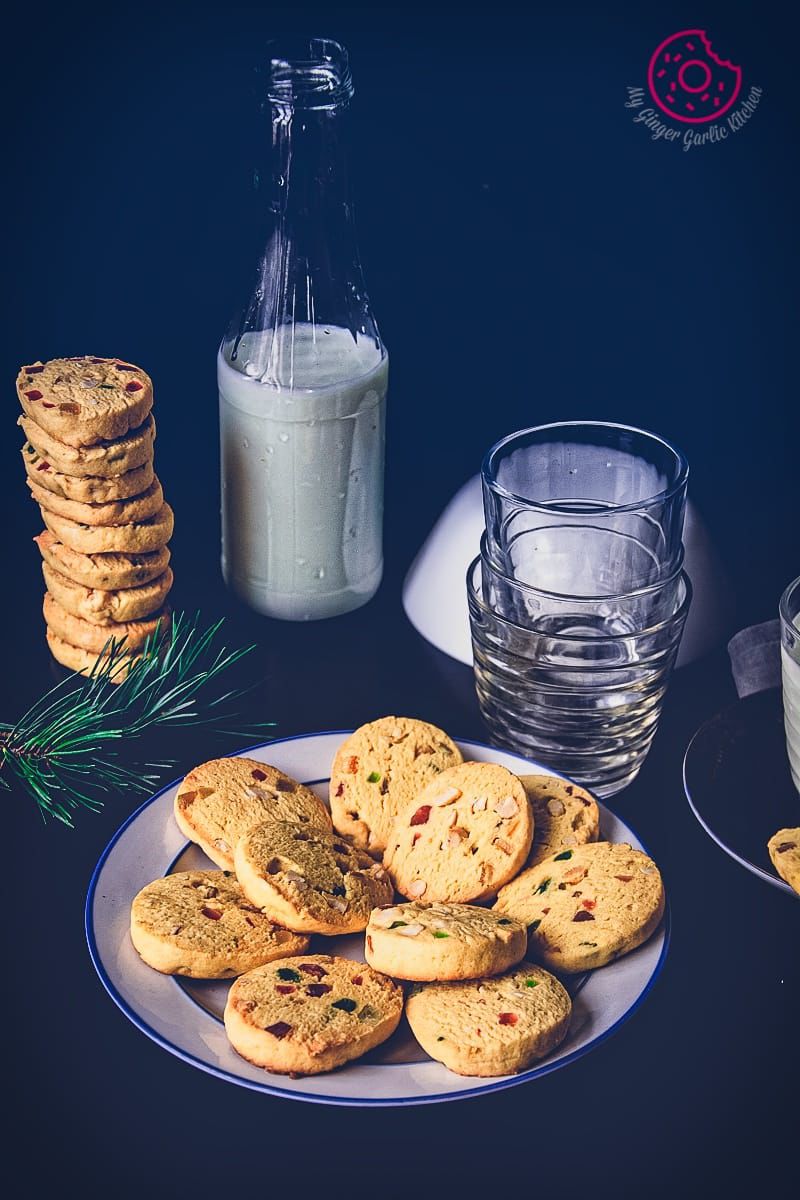 tutti frutti cookies and milk on a plate on a table