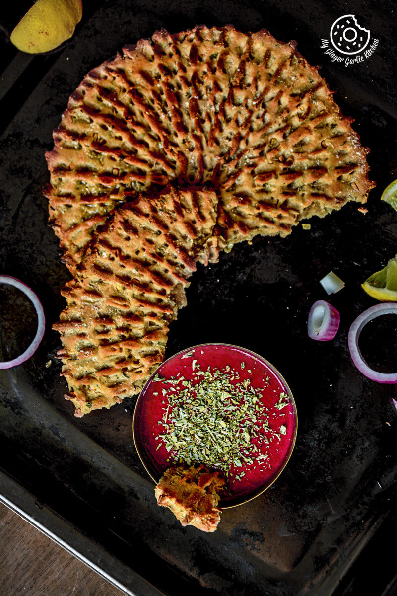 rajasthani khoba roti a tray with a bowl of red beet chutney, onions and lemons